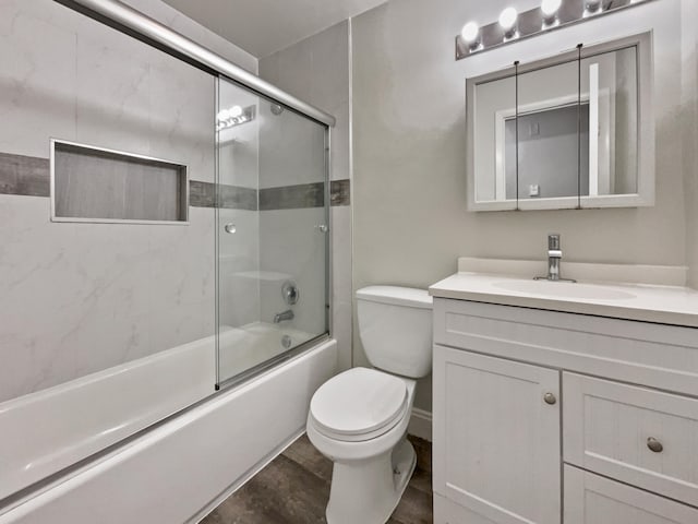 full bathroom featuring vanity, toilet, and shower / bath combination with glass door