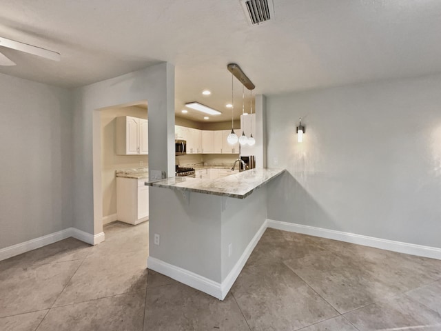 kitchen with kitchen peninsula, stainless steel appliances, ceiling fan, white cabinetry, and hanging light fixtures