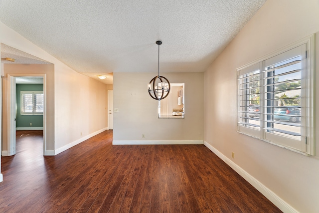 unfurnished room featuring a textured ceiling, dark hardwood / wood-style floors, and an inviting chandelier