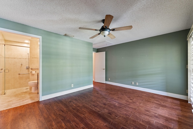 unfurnished room with a textured ceiling and dark hardwood / wood-style floors