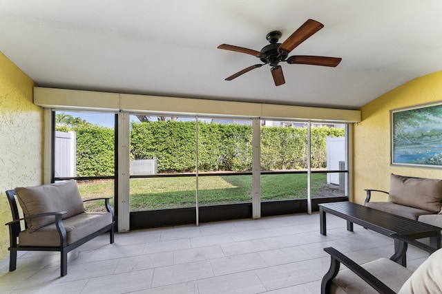 sunroom / solarium with ceiling fan, plenty of natural light, and lofted ceiling