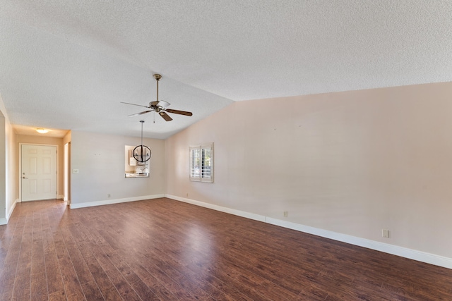 unfurnished room with dark hardwood / wood-style floors, ceiling fan, a textured ceiling, and vaulted ceiling