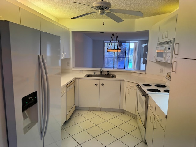 kitchen with ceiling fan, sink, a textured ceiling, white appliances, and light tile patterned floors