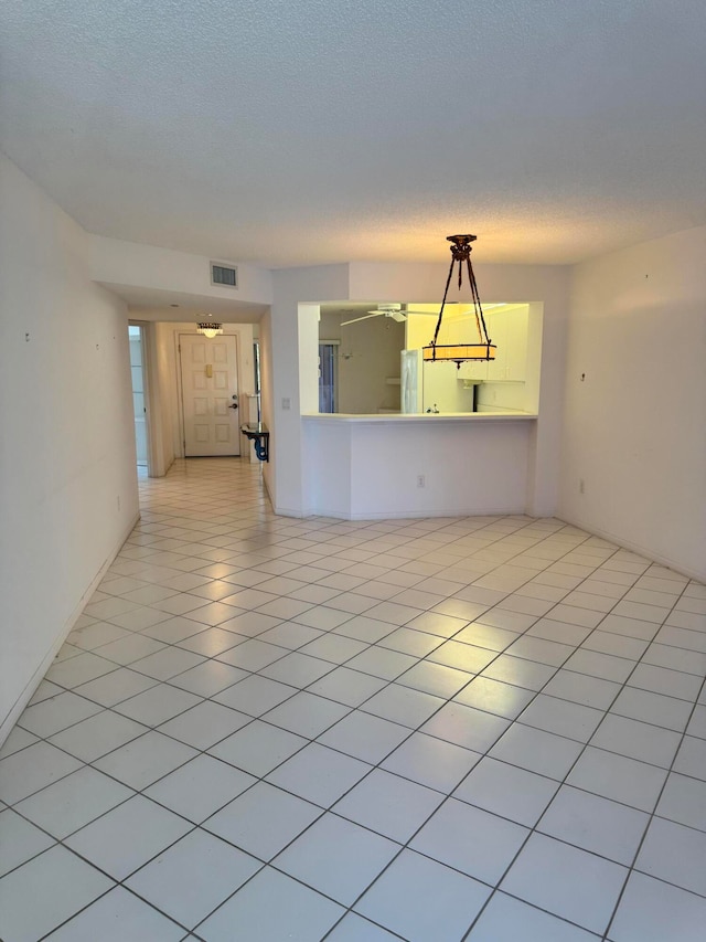 empty room with light tile patterned floors and a textured ceiling