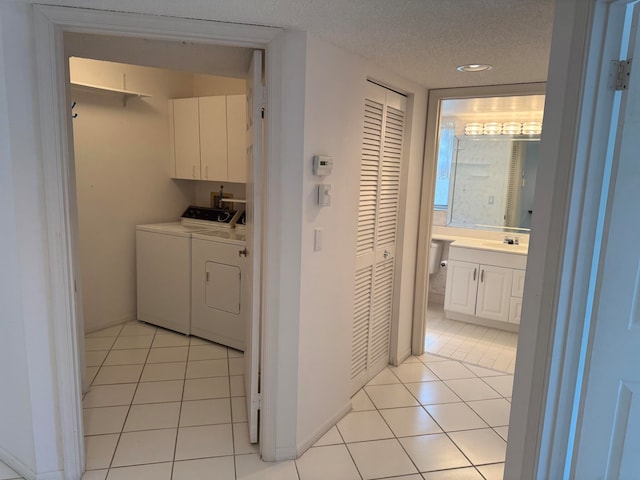 hall with washer and clothes dryer, light tile patterned floors, a textured ceiling, and sink