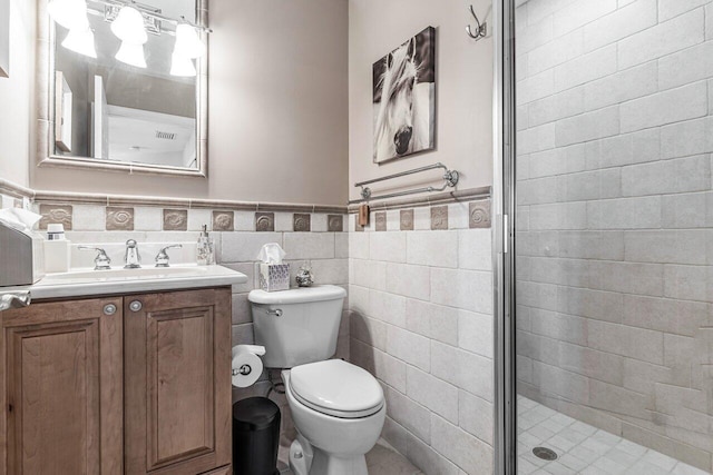 bathroom with vanity, toilet, tile walls, and walk in shower