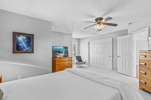 carpeted bedroom with ceiling fan and a closet