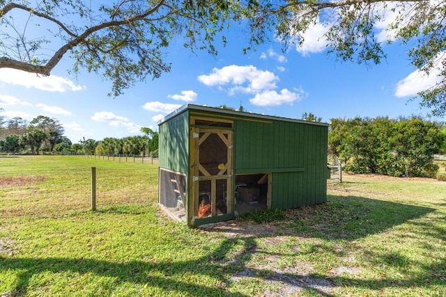 view of outdoor structure with a rural view and a lawn