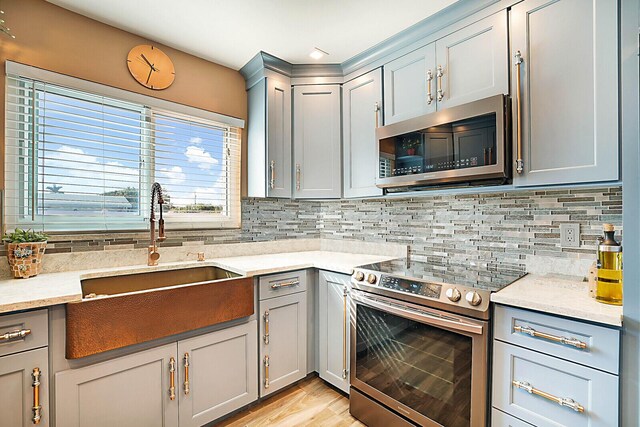 kitchen featuring sink, light stone countertops, and backsplash