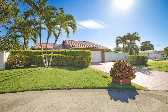 view of front of home with a front lawn and a garage