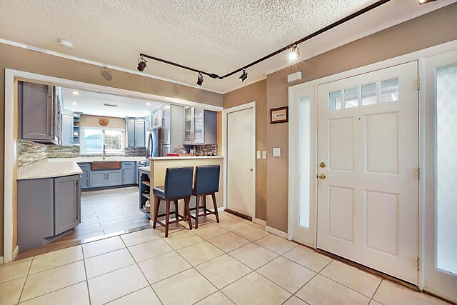 dining room featuring an inviting chandelier, light tile patterned floors, a textured ceiling, and ornamental molding