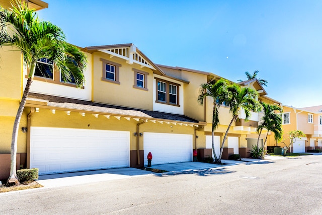 view of front of home with central air condition unit and a garage