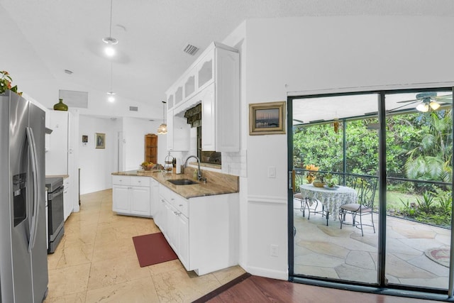 kitchen featuring pendant lighting, lofted ceiling, white cabinets, sink, and stainless steel appliances