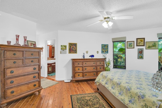 bedroom with ensuite bathroom, light hardwood / wood-style floors, a textured ceiling, and ceiling fan