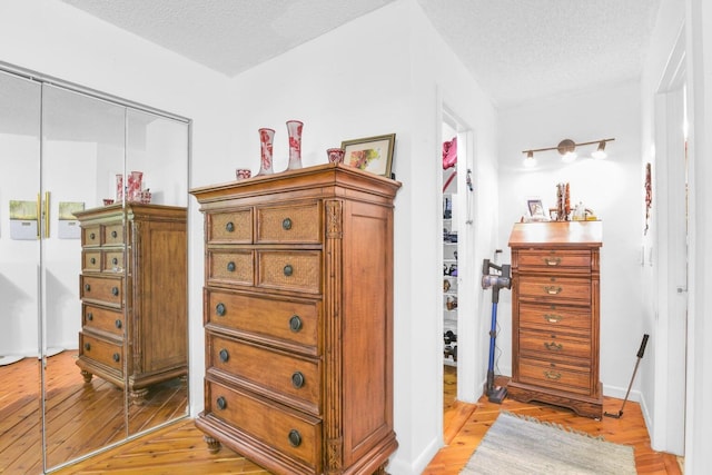 interior space featuring a closet, light hardwood / wood-style floors, and a textured ceiling