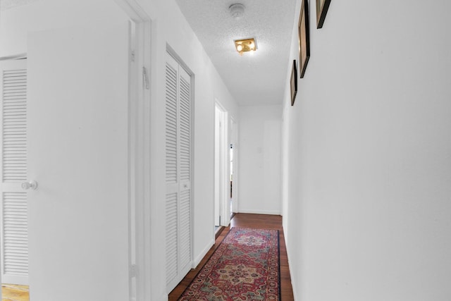 hall featuring dark hardwood / wood-style floors and a textured ceiling