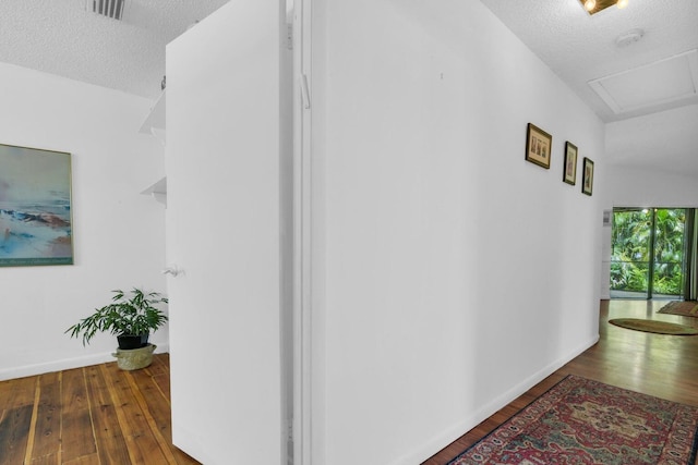 hallway featuring a textured ceiling and dark hardwood / wood-style floors