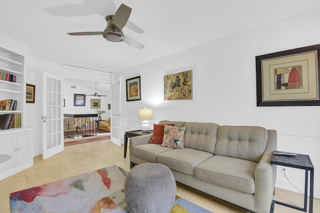 living room with tile patterned flooring, ceiling fan, built in shelves, and french doors