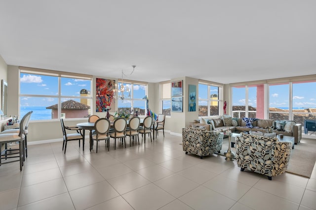 dining room featuring a water view, an inviting chandelier, and a healthy amount of sunlight