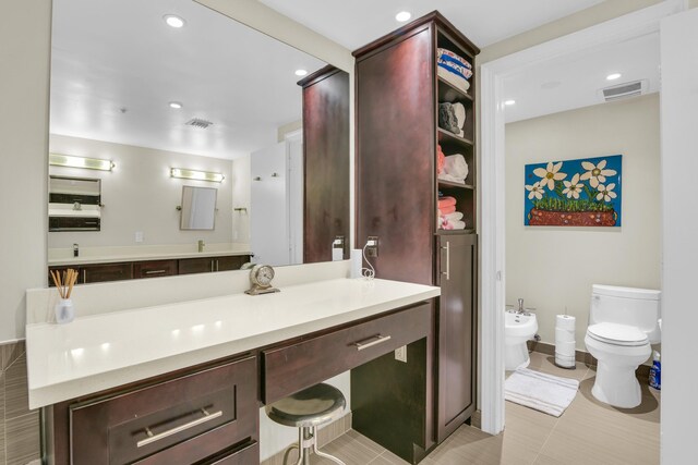 bathroom with vanity, toilet, and a bidet