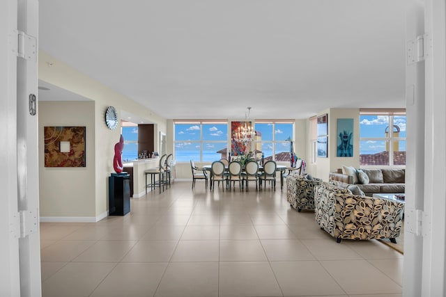 tiled living room with a notable chandelier and floor to ceiling windows