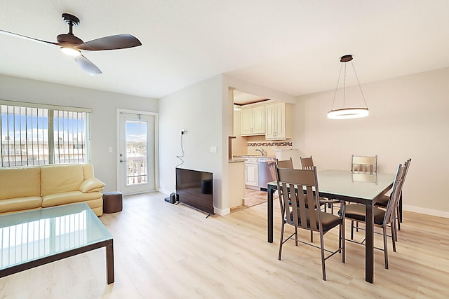 dining space with ceiling fan, sink, and light hardwood / wood-style floors