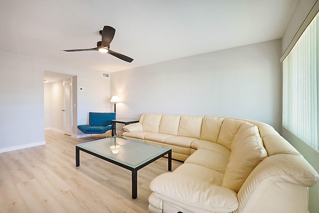 living room featuring light wood-type flooring, plenty of natural light, and ceiling fan