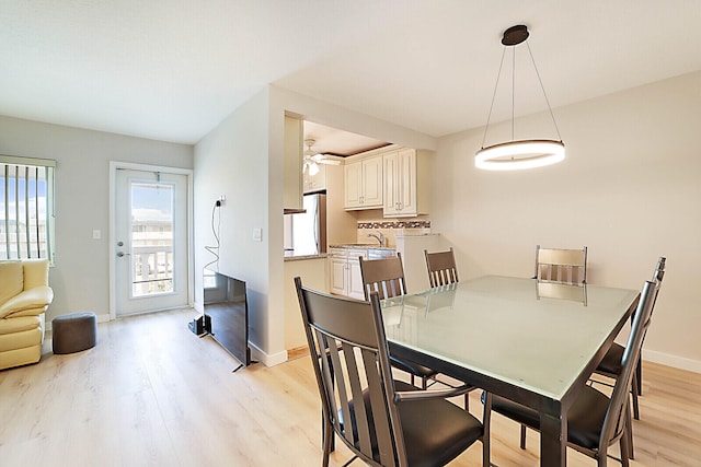 dining area with ceiling fan, light hardwood / wood-style floors, and sink