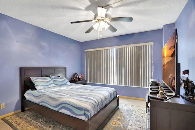 bedroom featuring a textured ceiling, ceiling fan, and light tile patterned flooring