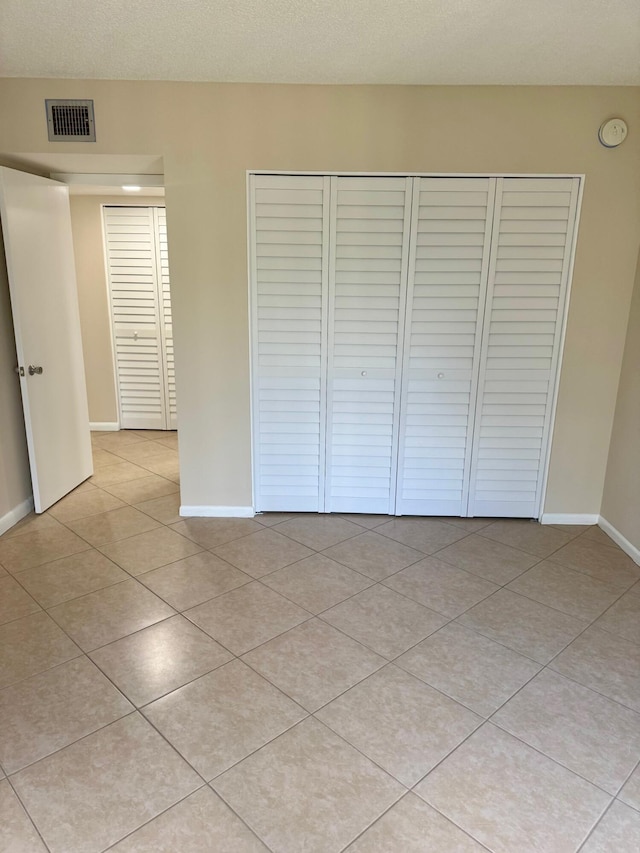 10777 W Sample Rd Unit 505, Coral Springs, FL 33065 - unfurnished bedroom featuring a closet and light tile patterned flooring
