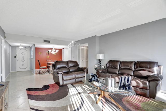 living room with light tile patterned floors, a textured ceiling, and a chandelier