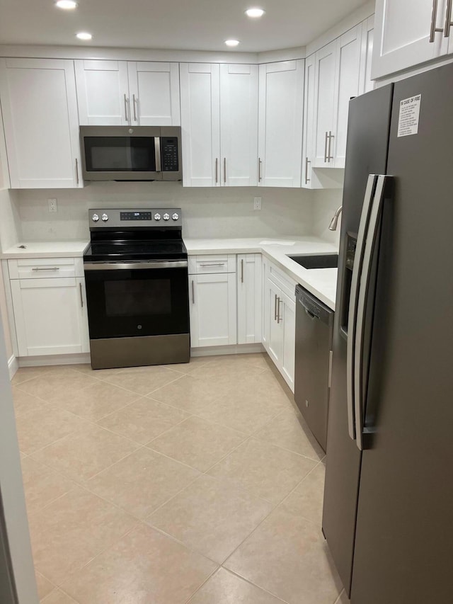 10777 W Sample Rd Unit 505, Coral Springs, FL 33065 - kitchen featuring stainless steel appliances, white cabinets, light countertops, light tile patterned floors, and recessed lighting
