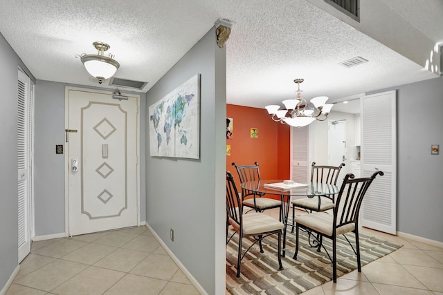 dining room featuring light tile patterned floors, a chandelier, and a textured ceiling