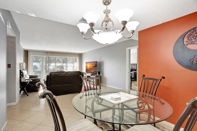 dining space featuring light tile patterned floors, a textured ceiling, and a notable chandelier