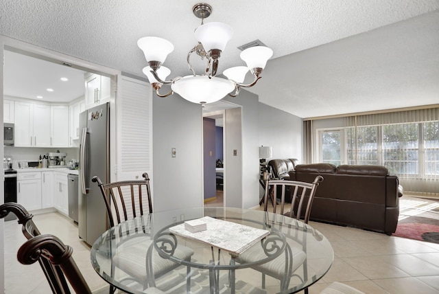 dining room with a notable chandelier, light tile patterned floors, and a textured ceiling