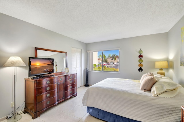 tiled bedroom featuring a closet and a textured ceiling