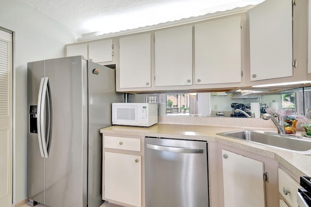 kitchen featuring appliances with stainless steel finishes, sink, and a textured ceiling