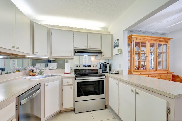 kitchen with white cabinetry, stainless steel appliances, sink, and a textured ceiling