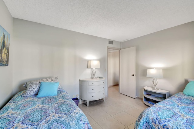 bedroom with light tile patterned floors and a textured ceiling