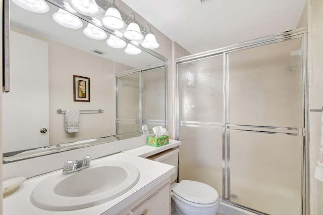 bathroom featuring vanity, an enclosed shower, and toilet