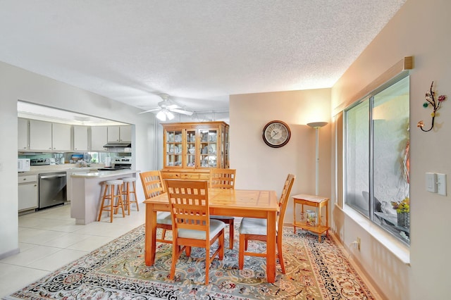 dining room with ceiling fan, a textured ceiling, and light tile patterned flooring