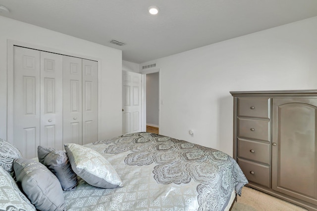 bedroom featuring light colored carpet and a closet