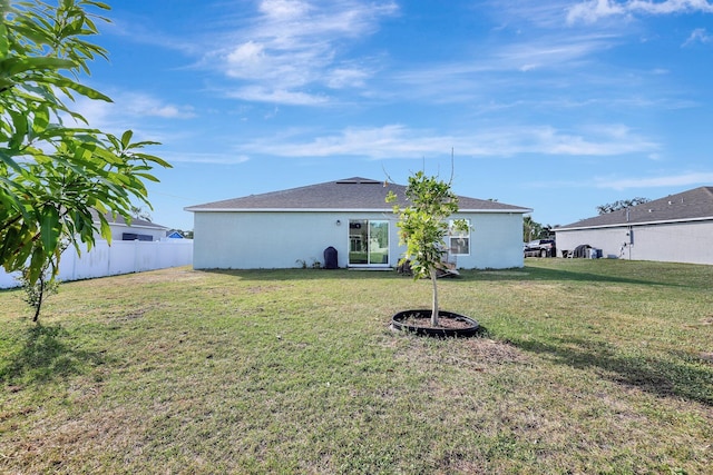 rear view of property featuring a lawn