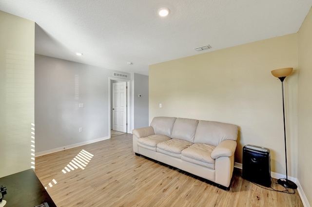 living room featuring a textured ceiling and light hardwood / wood-style floors