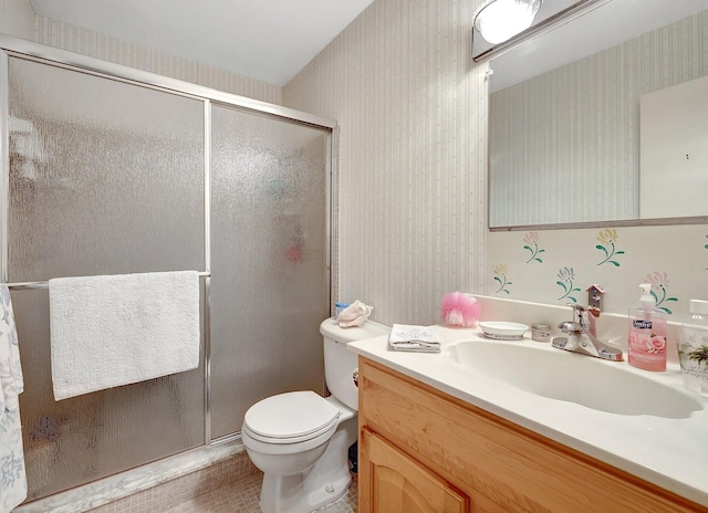 bathroom featuring a stall shower, vanity, toilet, and wallpapered walls