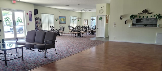 living area featuring ceiling fan, baseboards, and wood finished floors