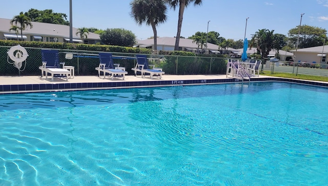 pool with a patio area and fence