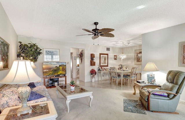 living area featuring a textured ceiling, visible vents, and a ceiling fan