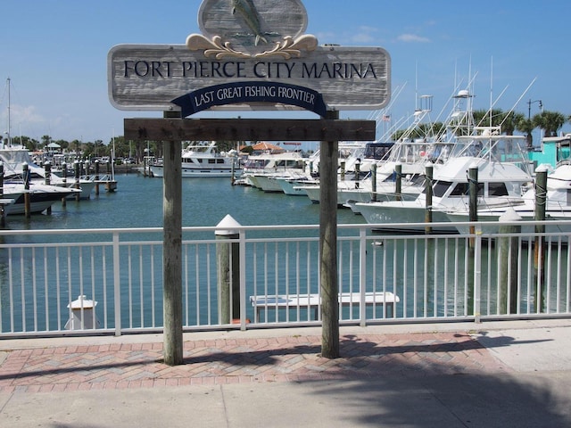 view of dock with a water view and fence