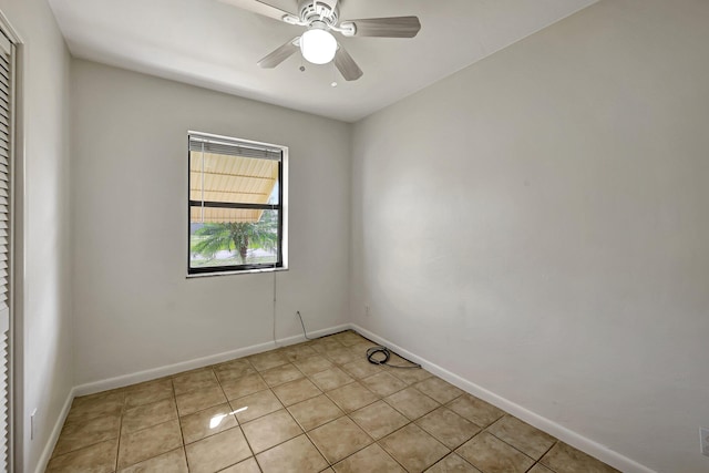 tiled spare room featuring ceiling fan